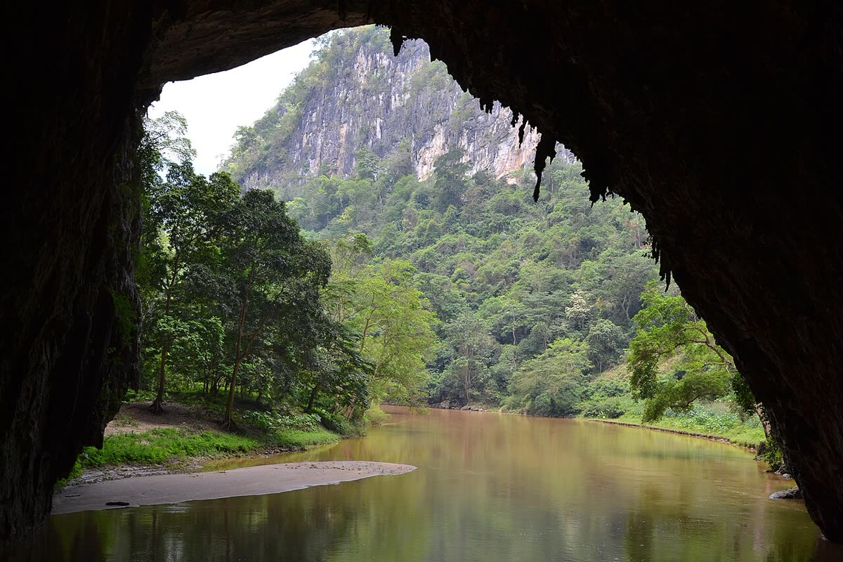 Looking out of Puong Cave at the Nang River and a forested limestone cliff