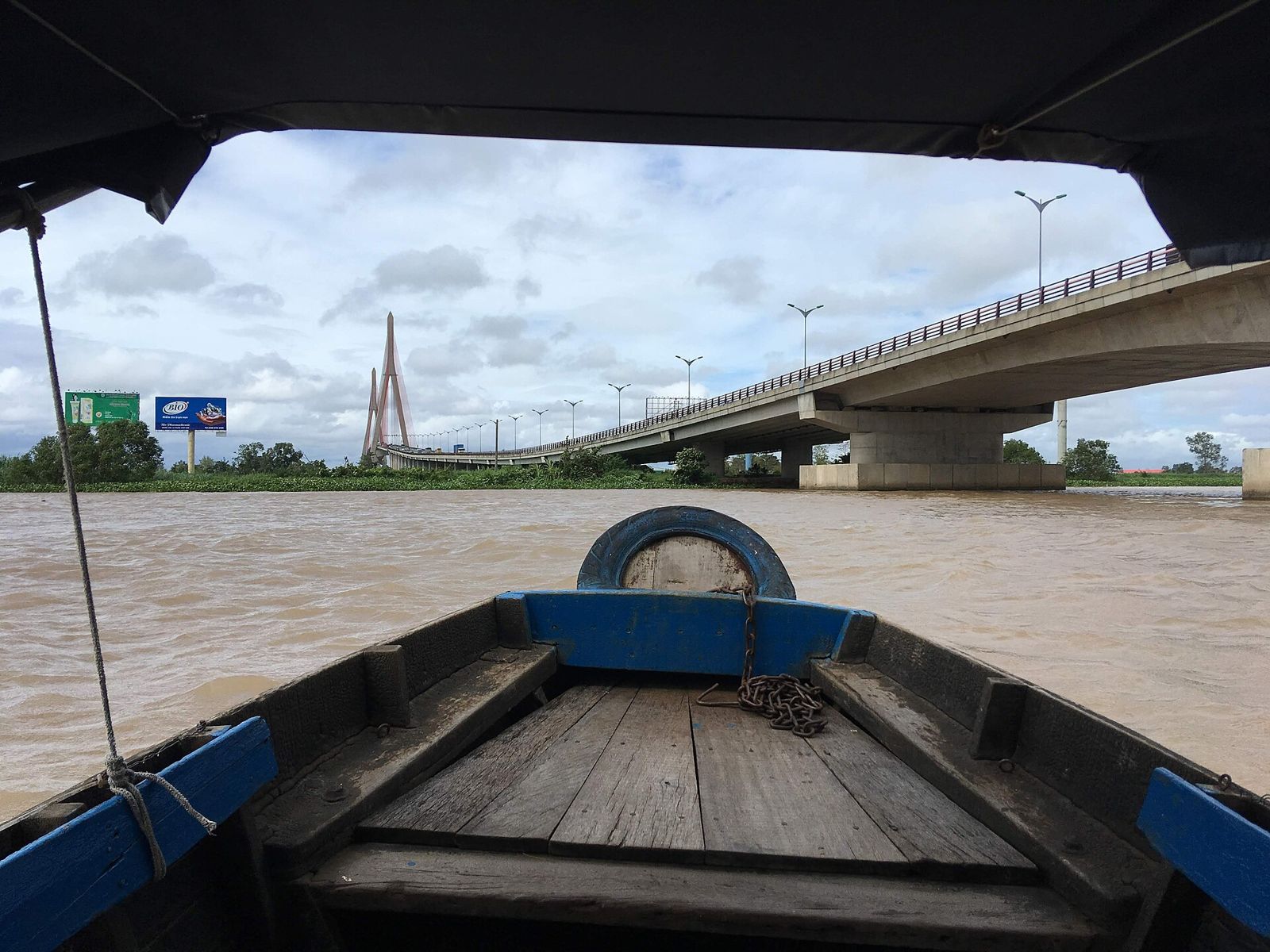 Can Tho Bridge seen from the bow of a wooden boat on the Hau River