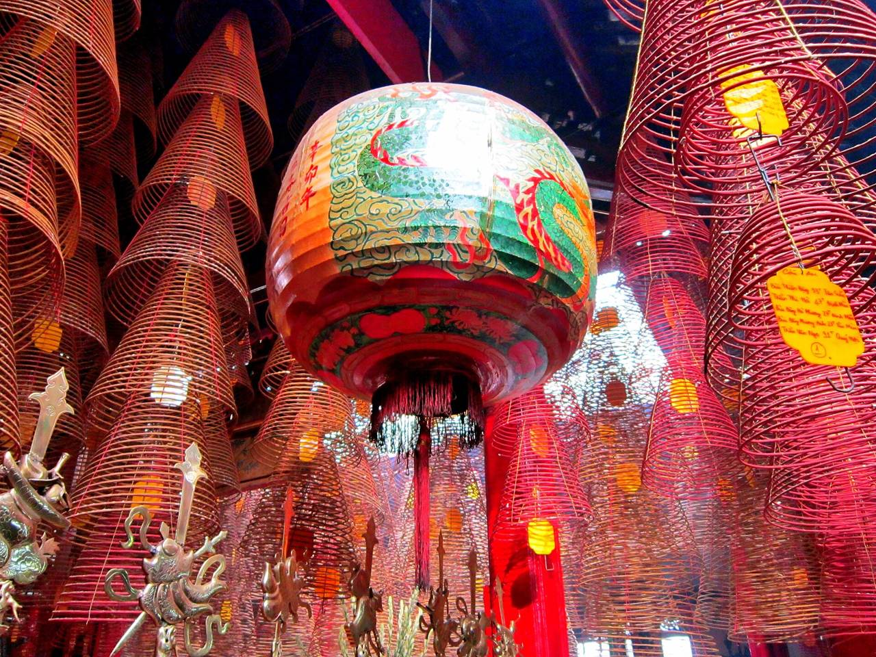 Hanging incense coils and a painted lantern inside Ong Pagoda in Can Tho