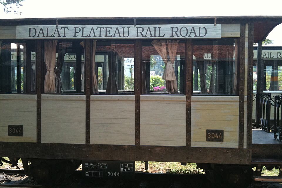 A wooden tourist train car beside Da Lat Railway Station