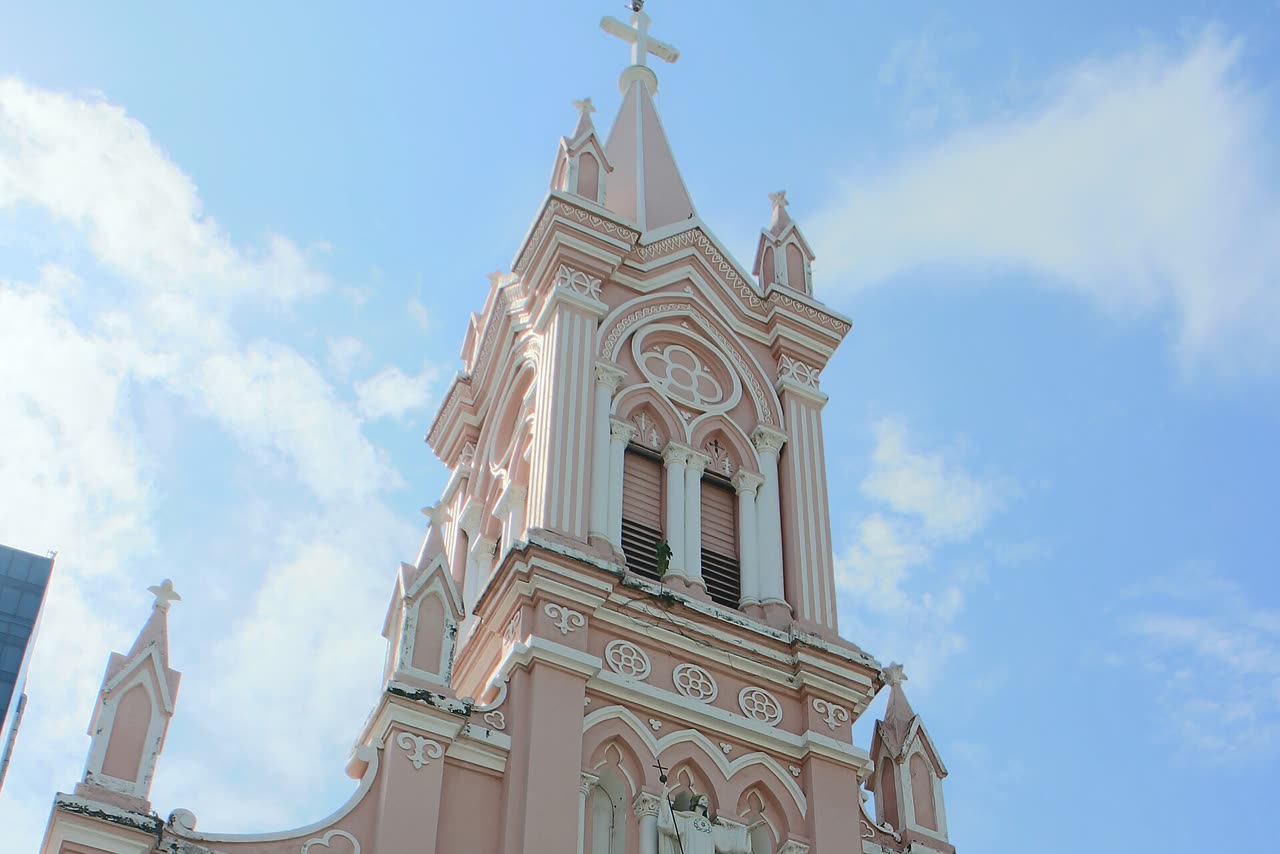 The cathedral spire and cross against a blue sky