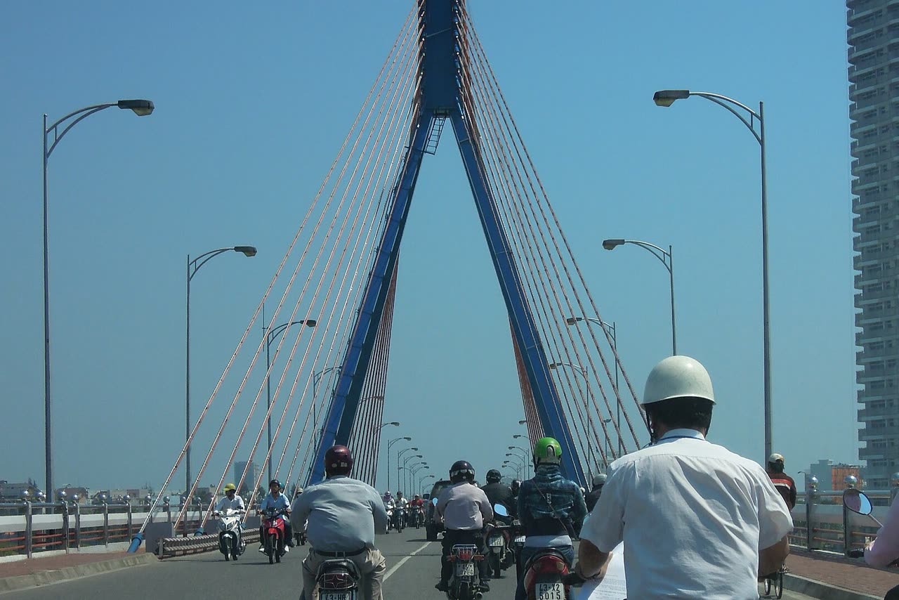 Motorbikes crossing the Han swing bridge, with the blue pylon over the river