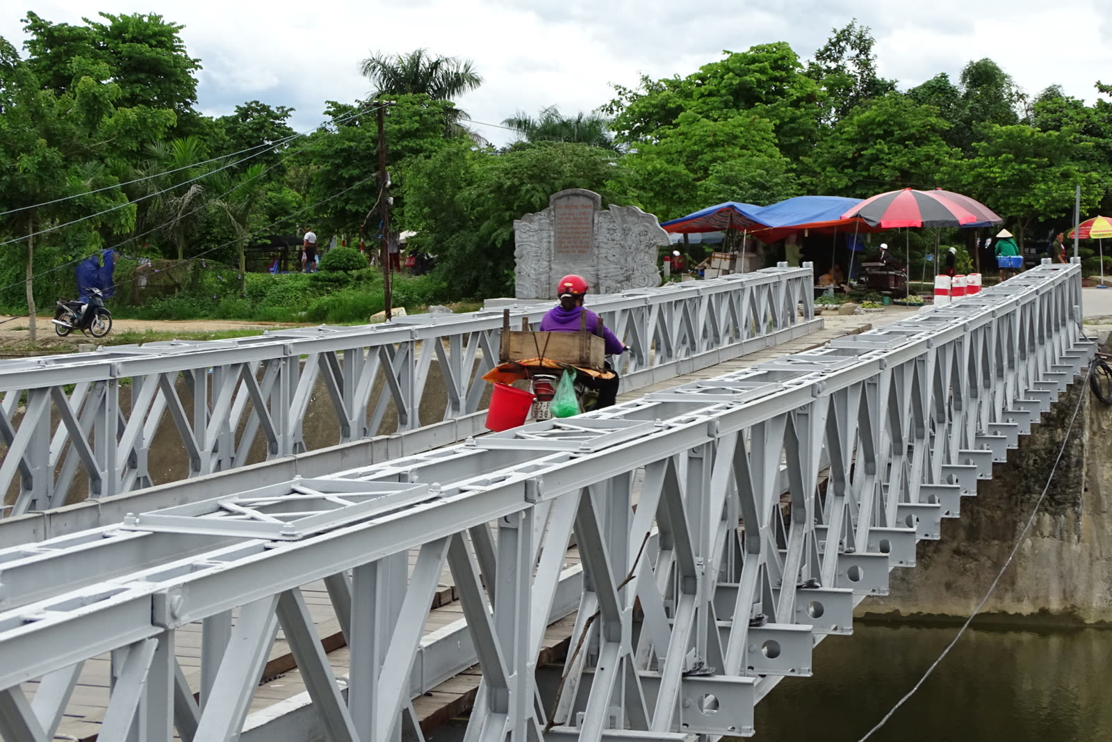 A rider crossing the Muong Thanh truss bridge over the Nam Rom in Dien Bien Phu