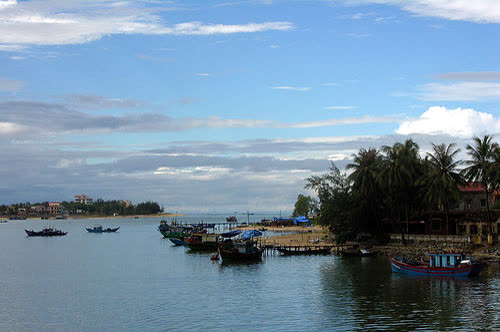 Boats on the Nhật Lệ with coconut palms along the bank