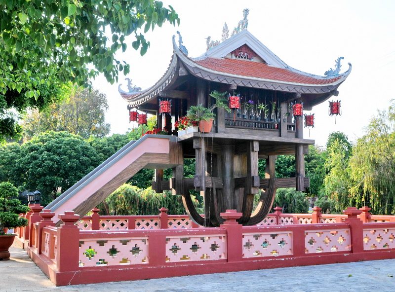 One-pillar wooden pavilion on a carved column, with a stair and a red fence, in Dong Xanh Park