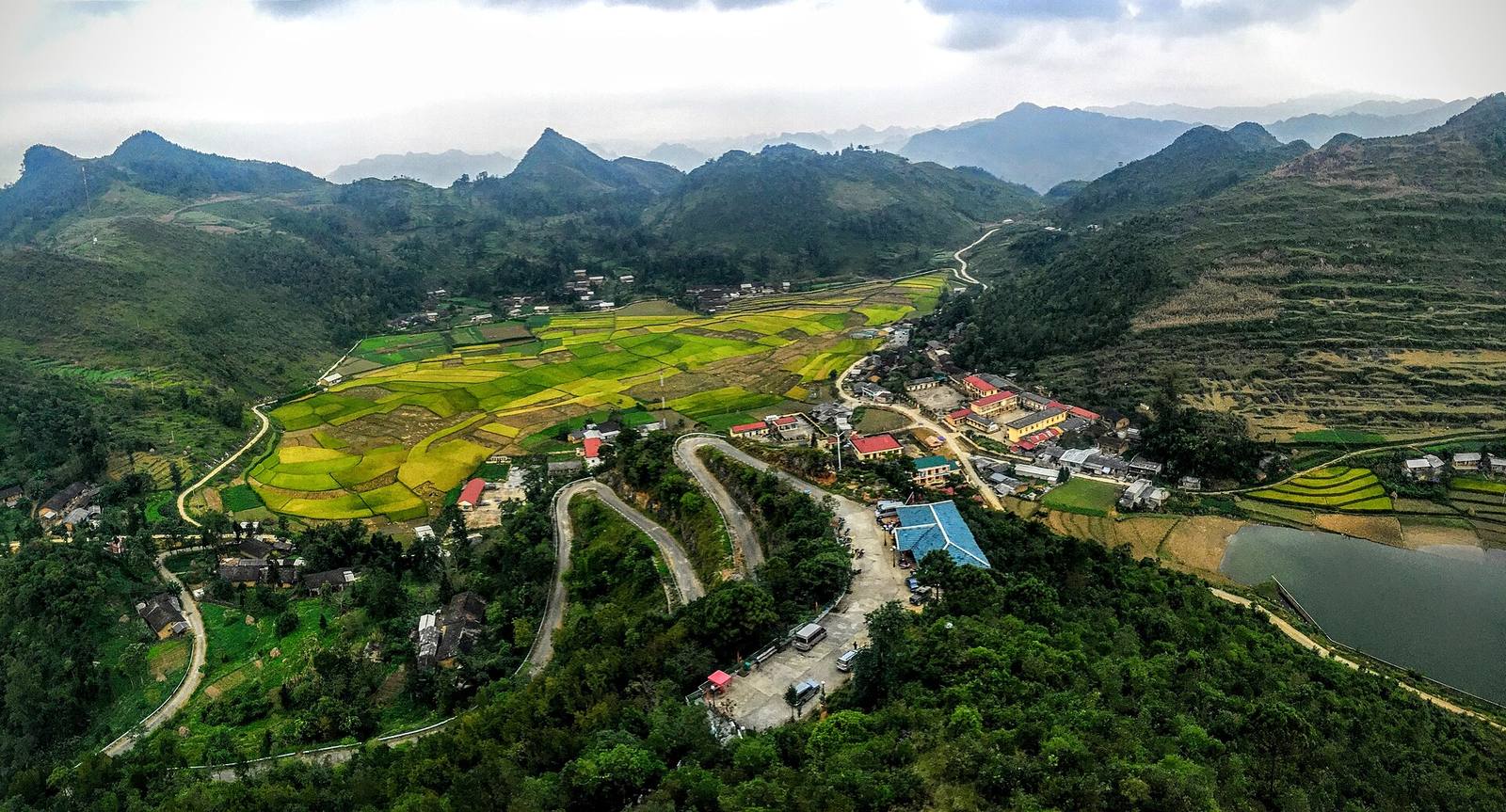 Switchback road and rice fields among karst hills at Lũng Cú
