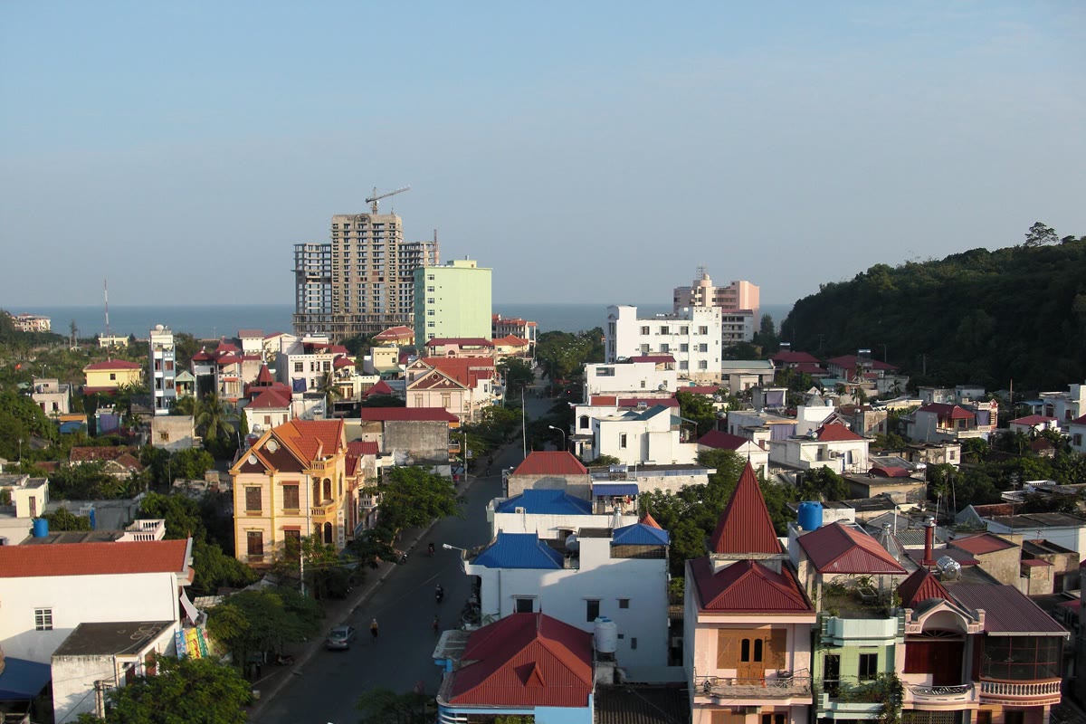 Do Son town from above, a green hill on the right and the sea on the horizon