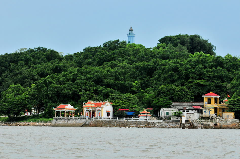 Hòn Dấu from the water, the lighthouse above the trees