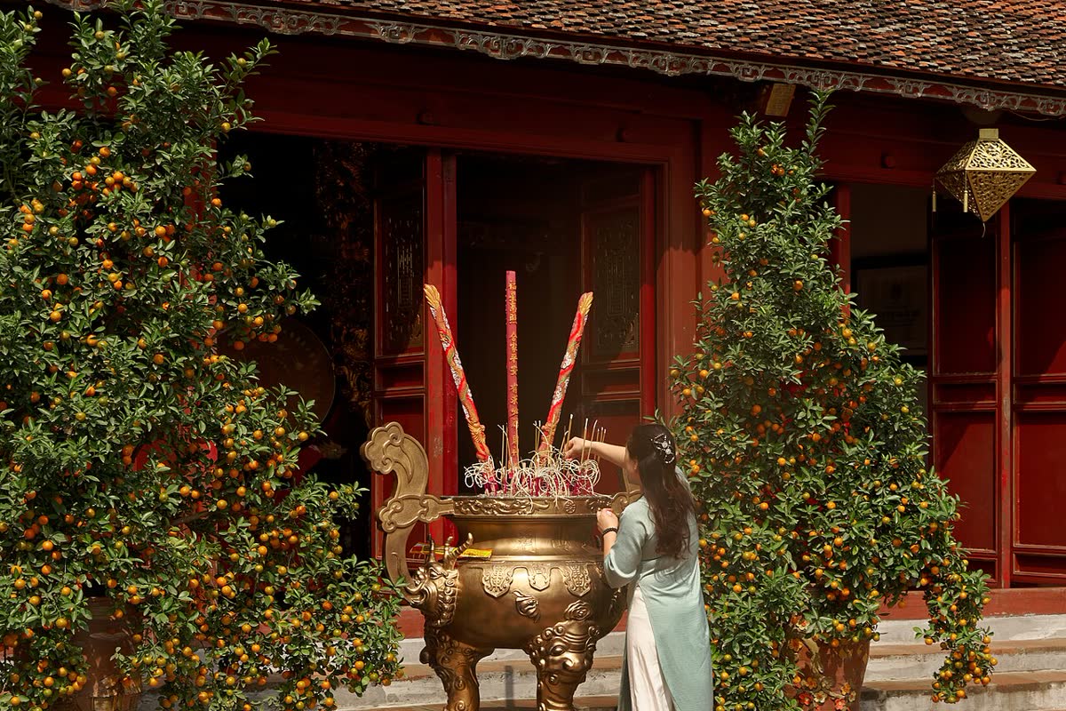 A visitor at the incense burner in Ngoc Son Temple