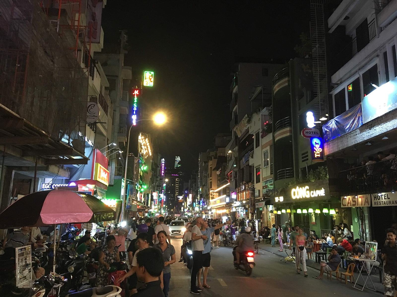 Outdoor tables and neon signs on Bui Vien at night