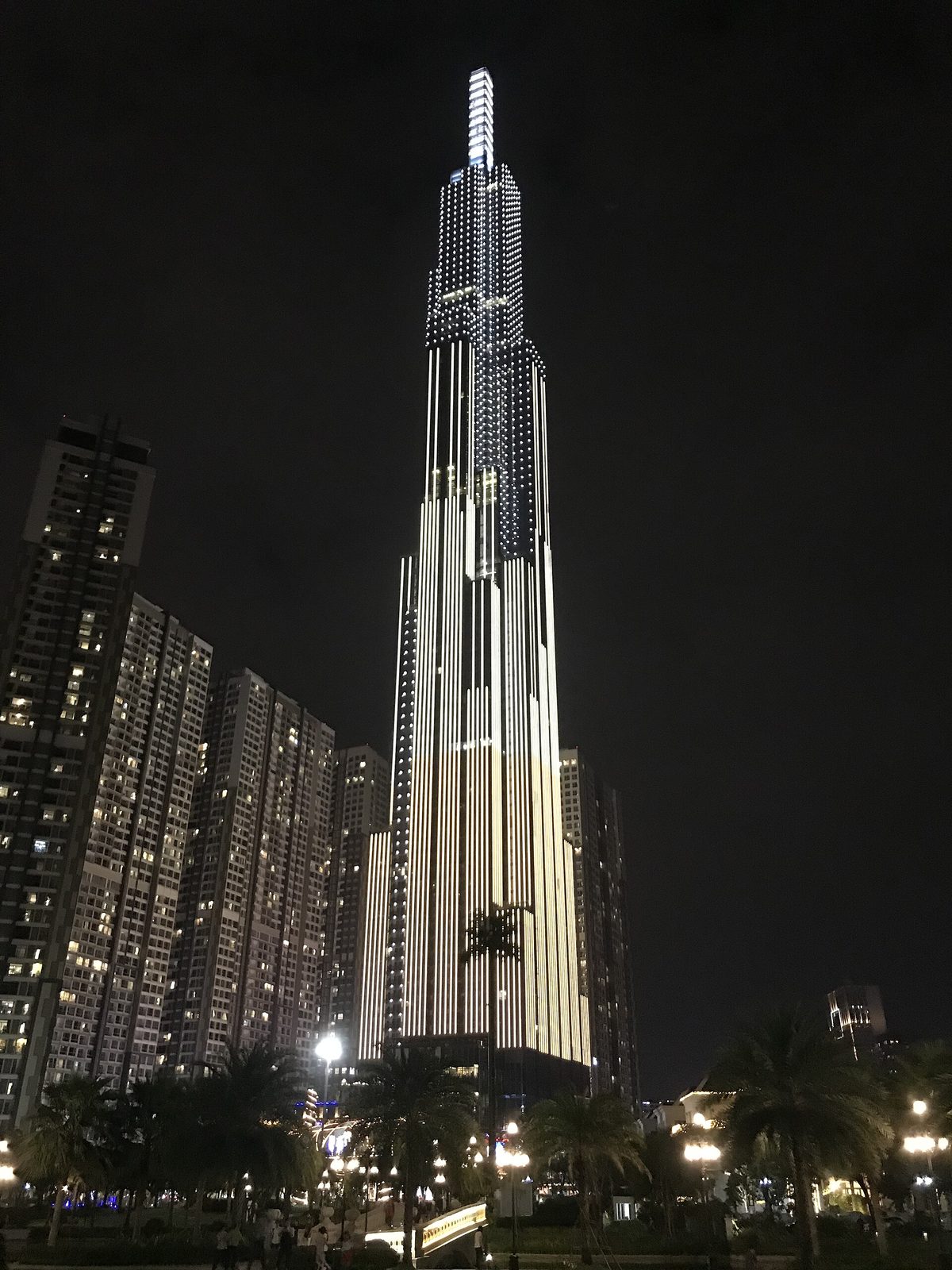 Landmark 81 at night above the riverside blocks