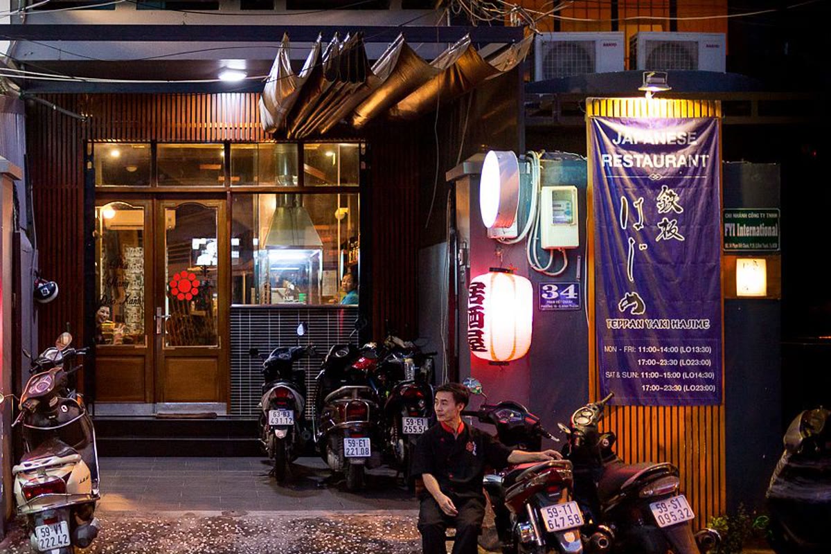 Night view of a Japanese restaurant front numbered 36 with a noren curtain