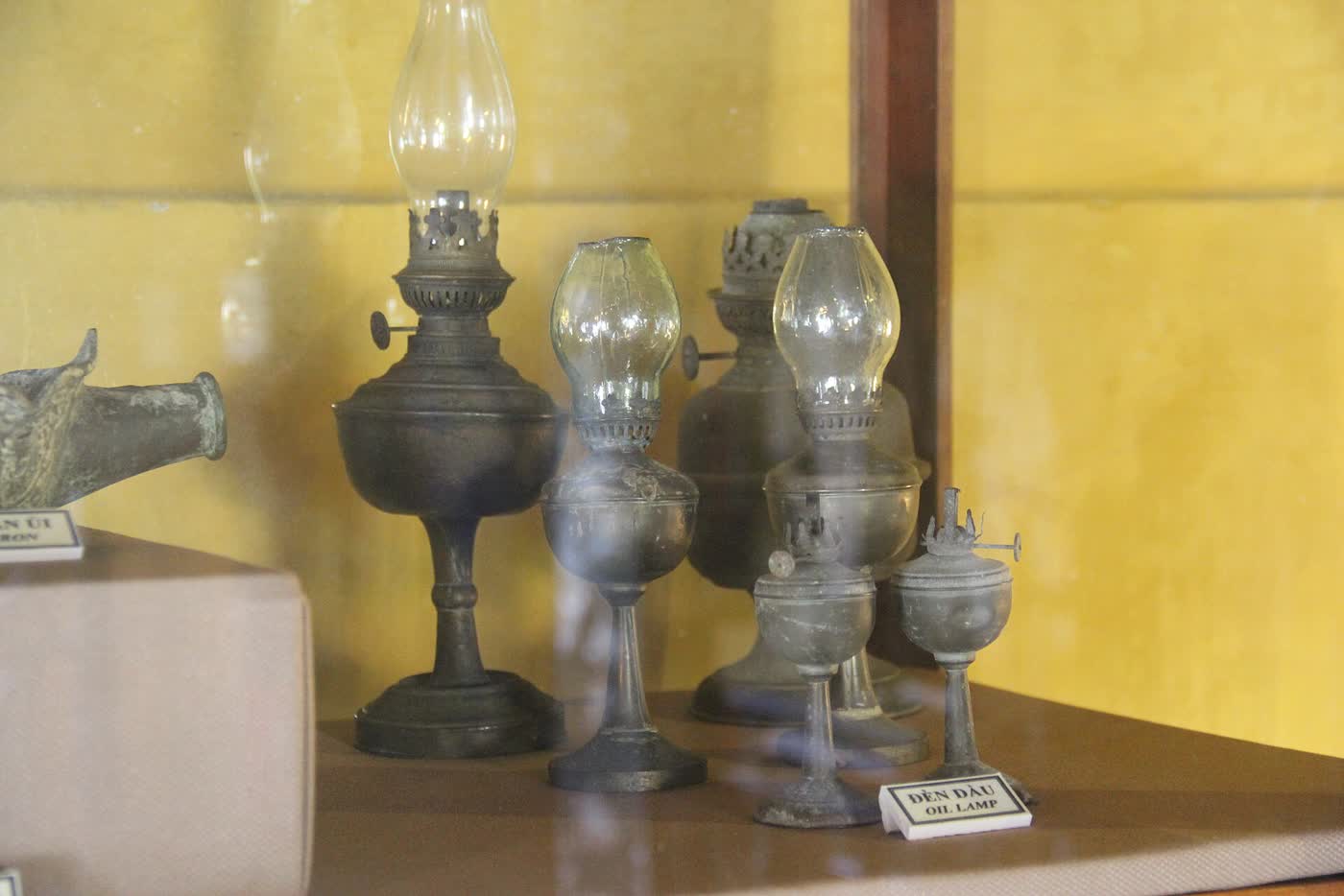A row of metal and glass oil lamps in the Museum of Folk Culture in Hoi An