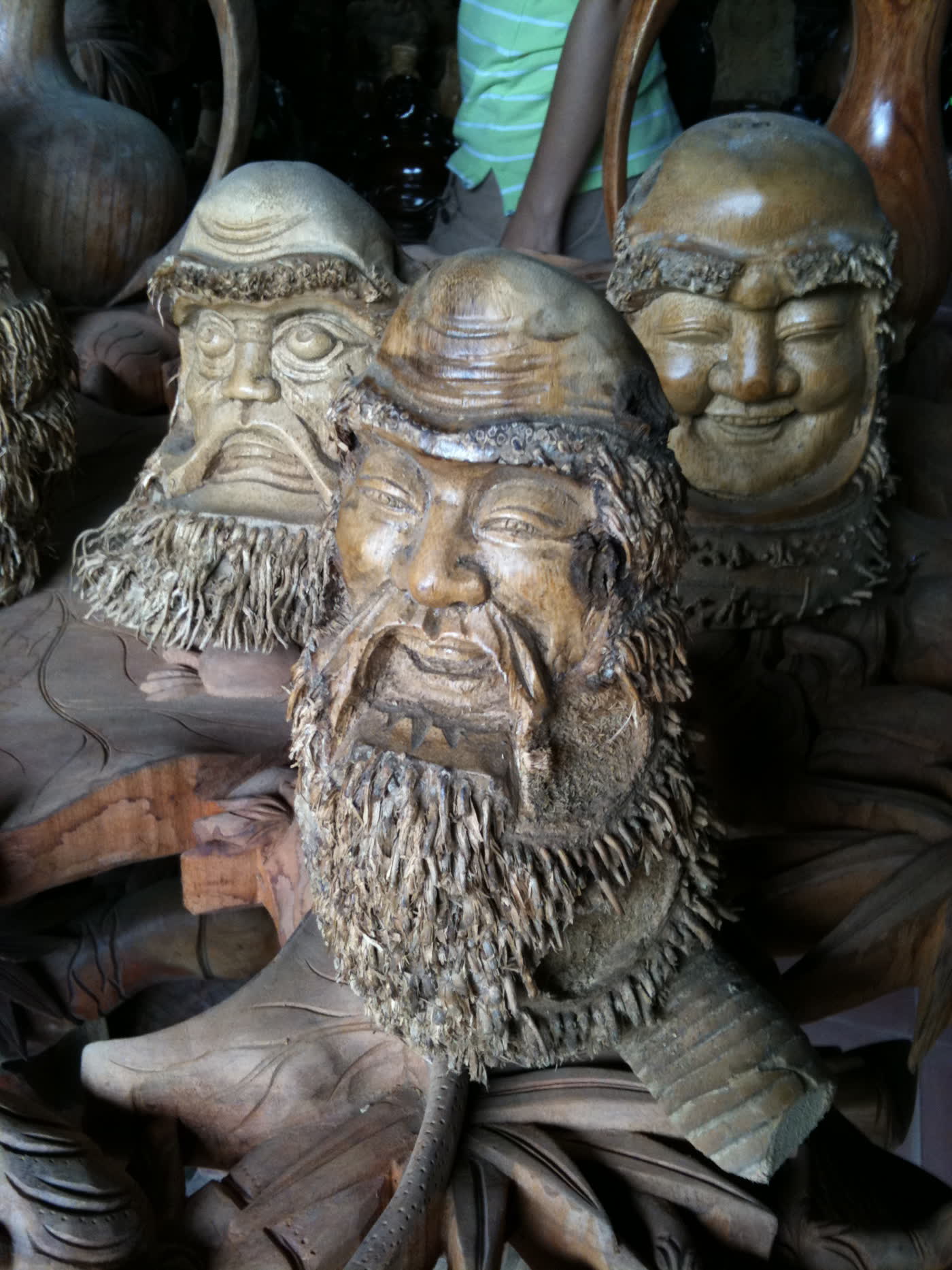 Three carved wooden faces with beards, made in Kim Bong carpentry village