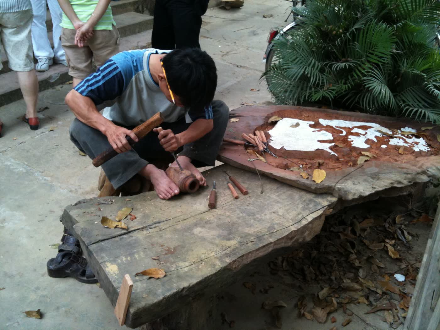 A carver at work on a timber slab in Kim Bồng