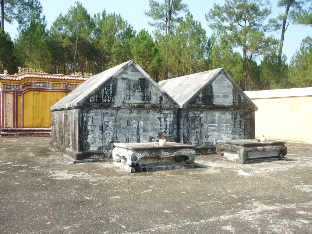 Two stone tombs side by side among trees at the tomb of Gia Long