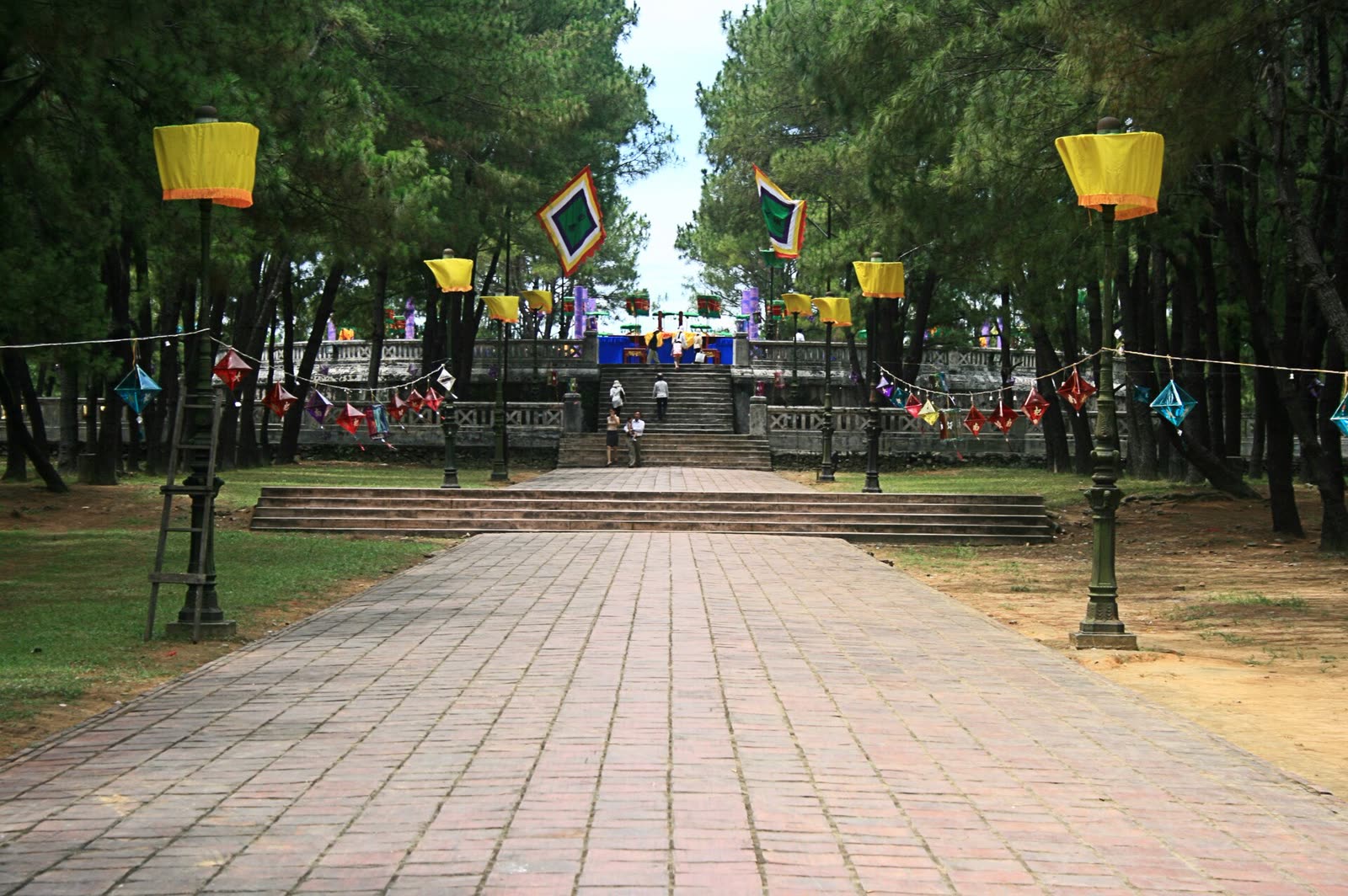 The pine walk and flags toward the Nam Giao terraces