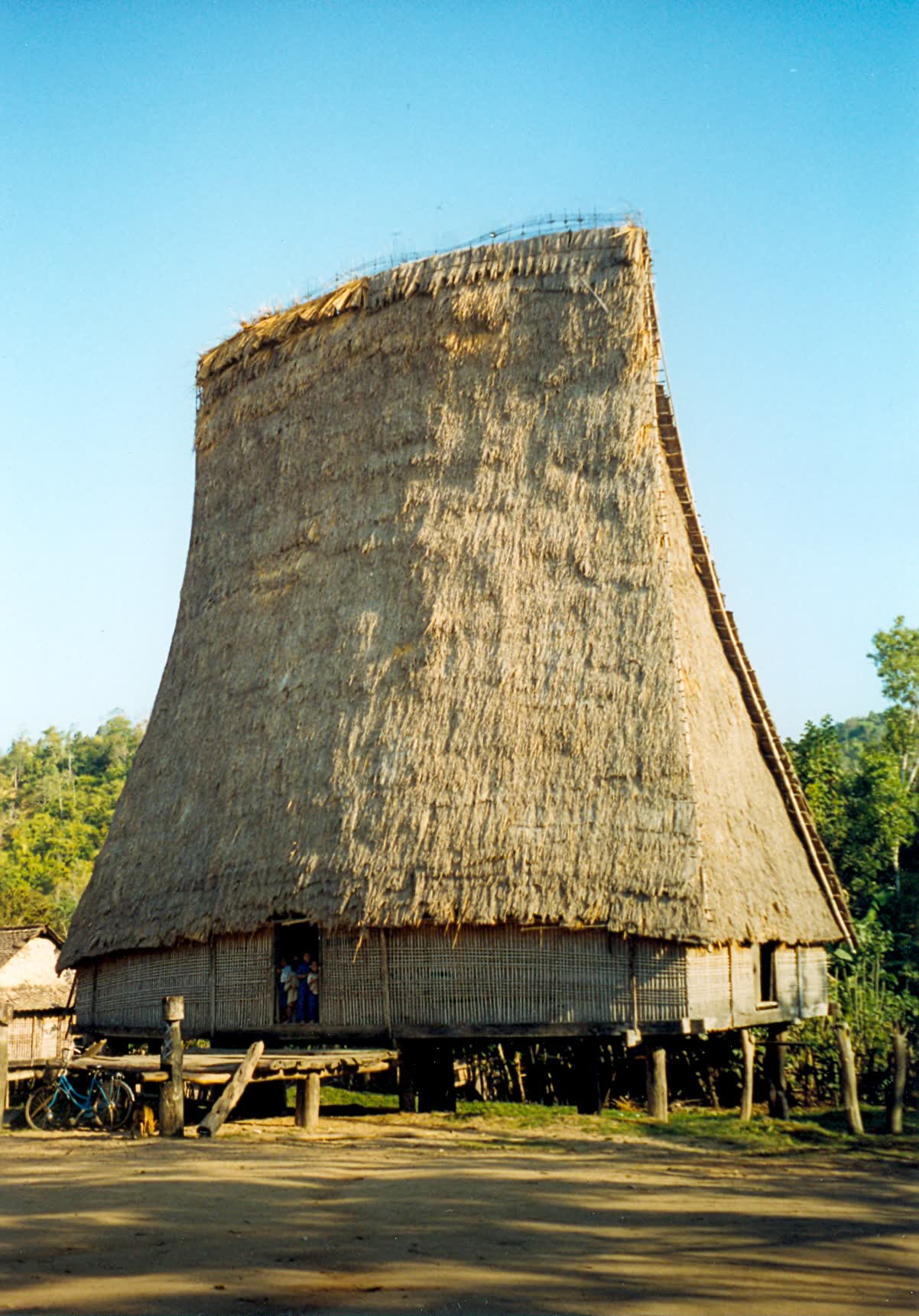 A tall thatched communal house on stilts in Kon K'Tu village