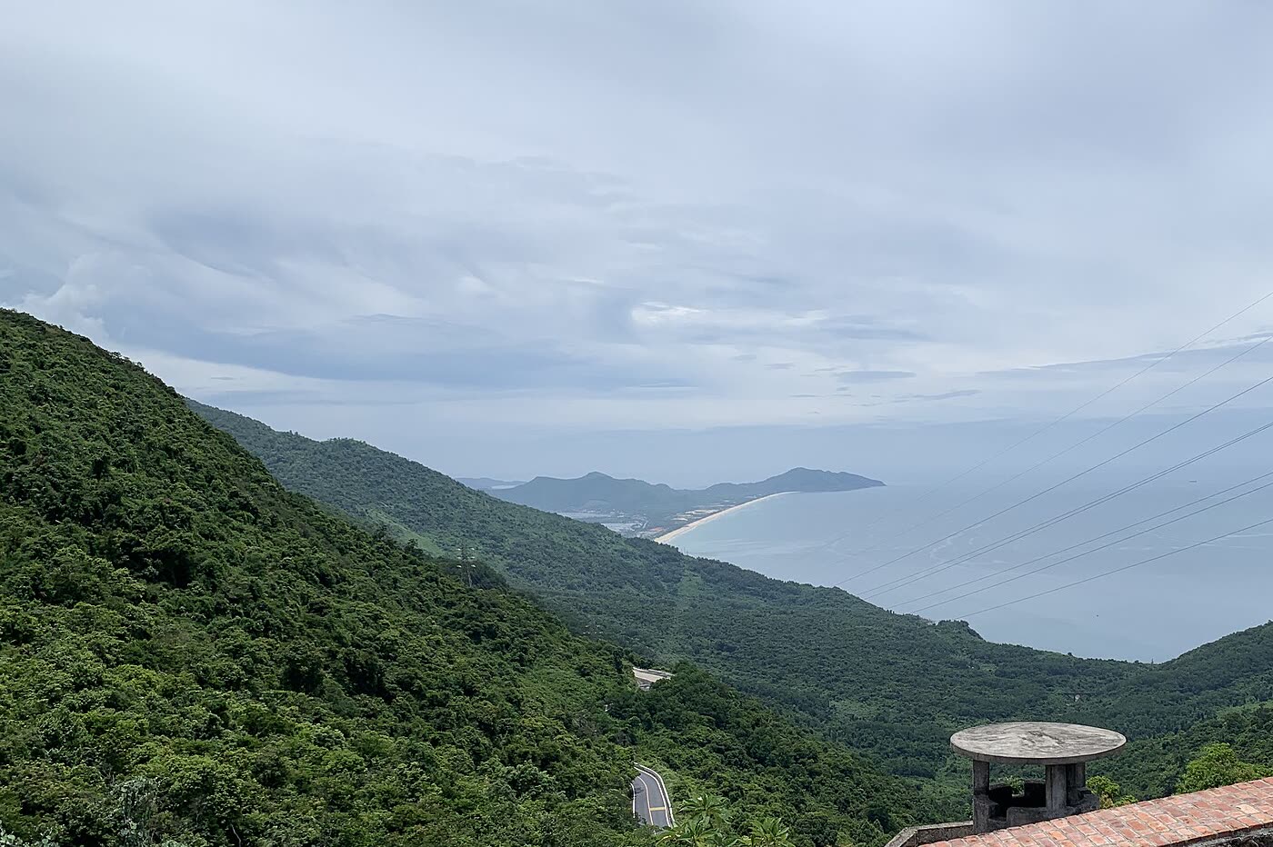 The curved Lang Co beach seen from the Hai Van Gate, with forested ridges in front