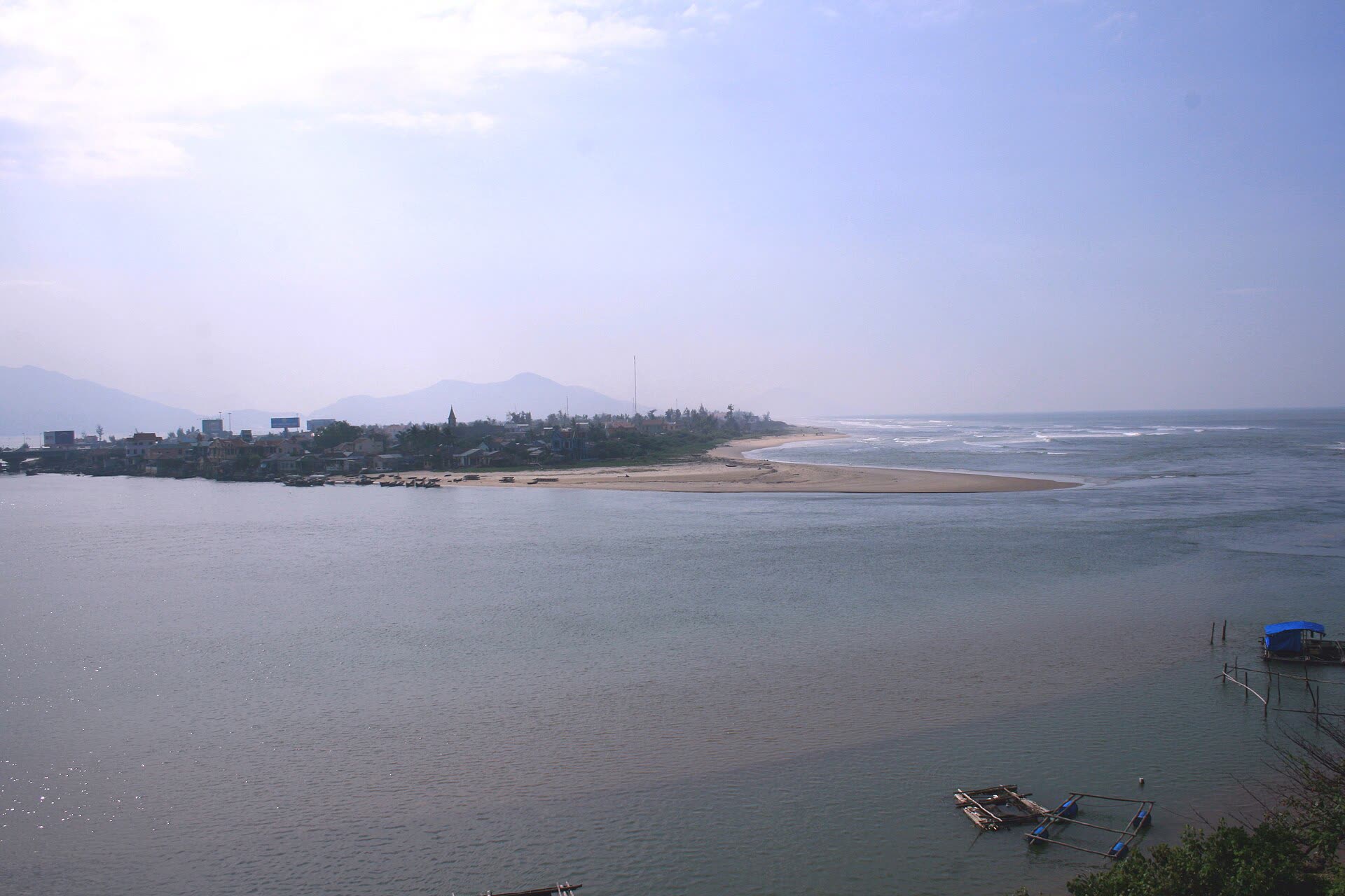 A long sand spit at Lang Co, town and boats on the left, open sea on the right