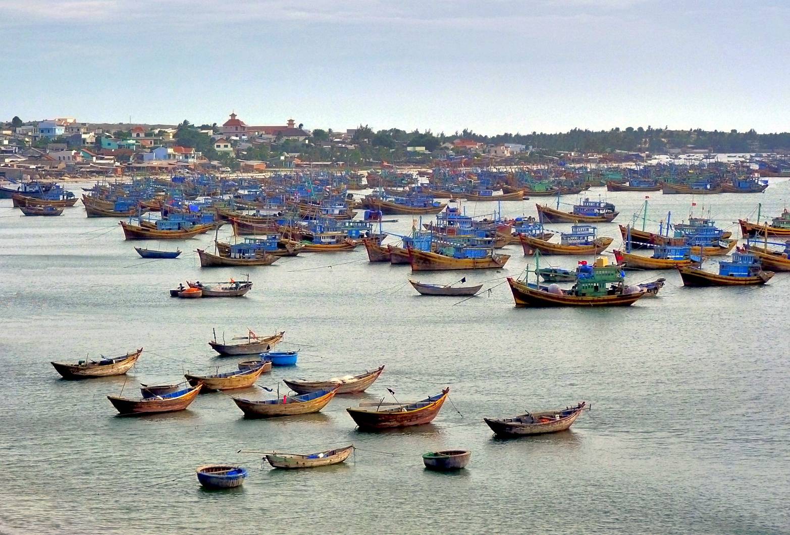 Wooden fishing boats crowded in the Mui Ne harbor