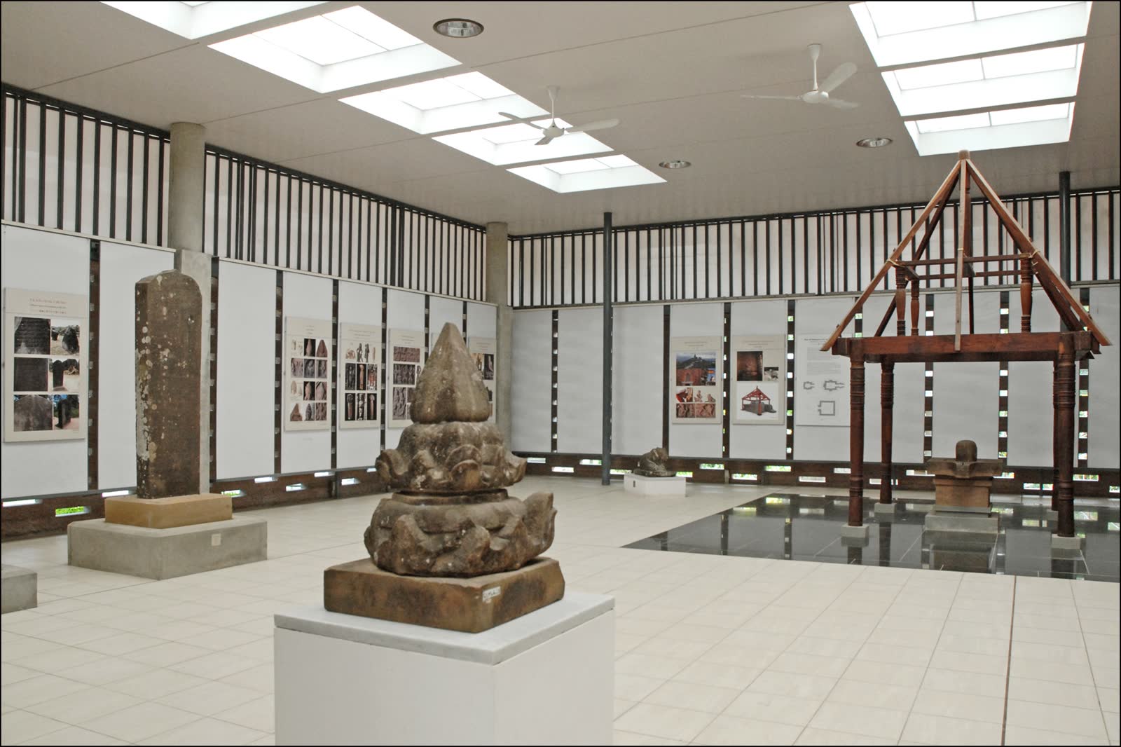 A carved pedestal in the gallery, with the hall behind it