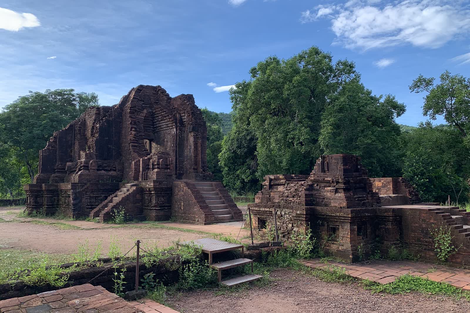 Brick towers of group G at My Son, with trees behind the ruins
