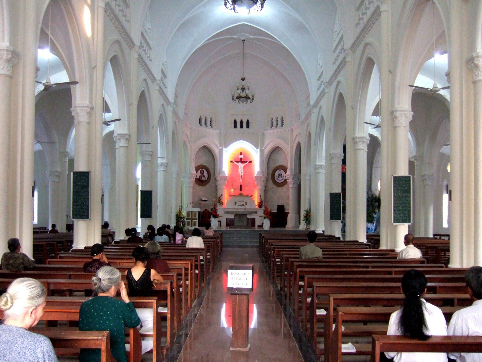 The nave of My Tho Cathedral, pews leading to the altar and crucifix