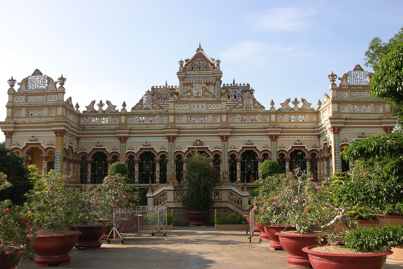 The ornate front of Chùa Vĩnh Tràng, with red pots in the courtyard