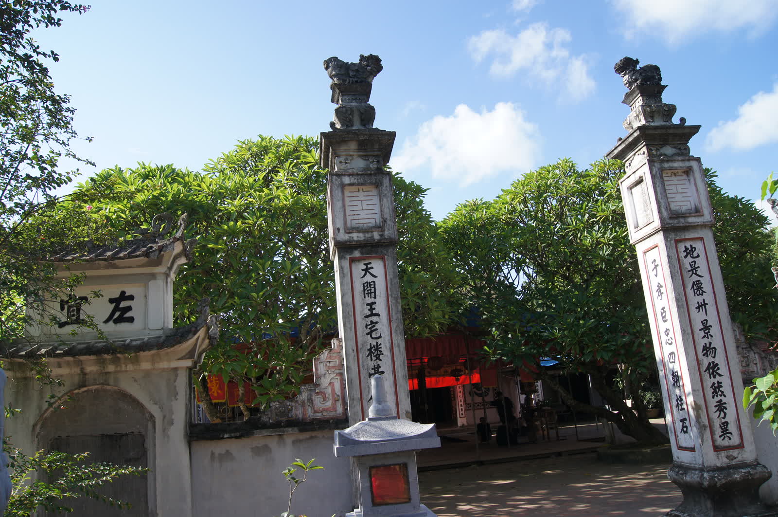 Gate pillars, trees, and the hall behind