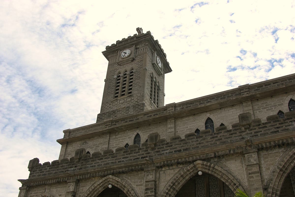 The stone clock tower and the arched front of the cathedral