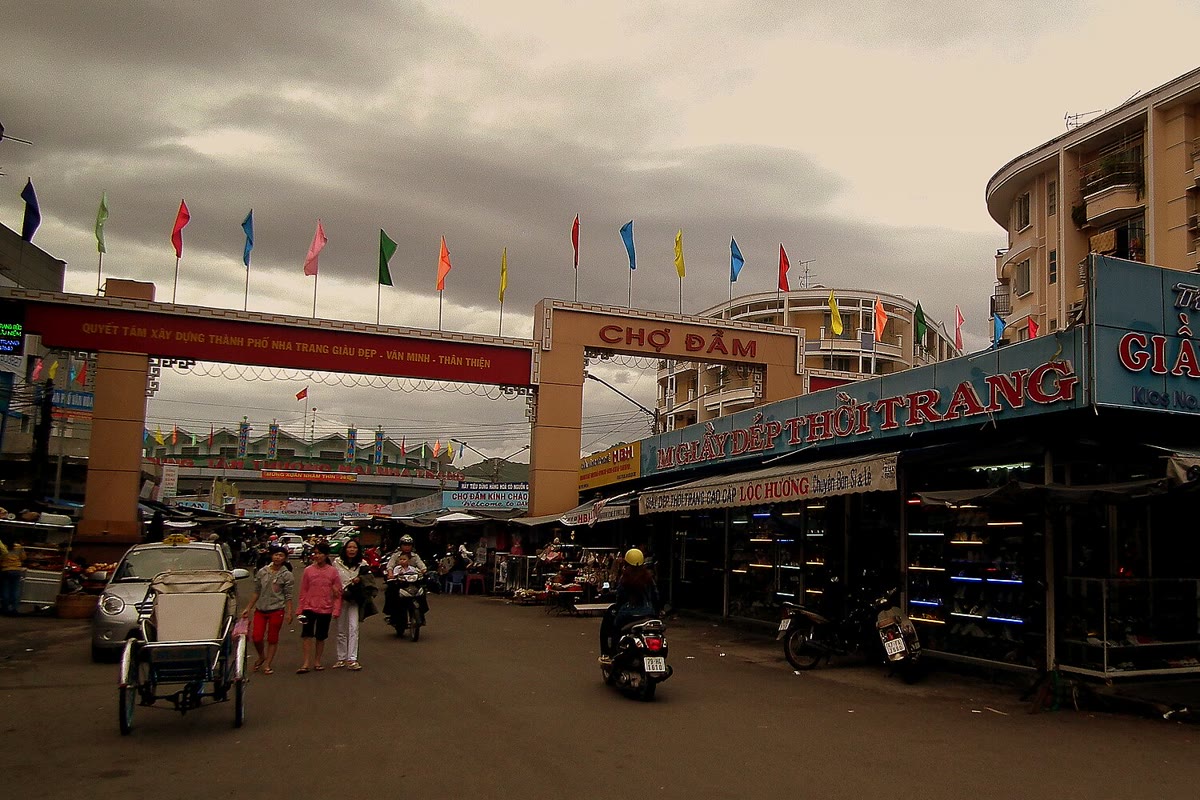 The Chợ Đầm gate, flags, and the street in front