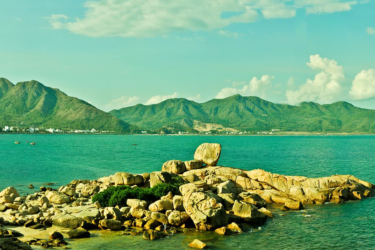 The stacked rocks of Hòn Chồng, with the bay and the hills