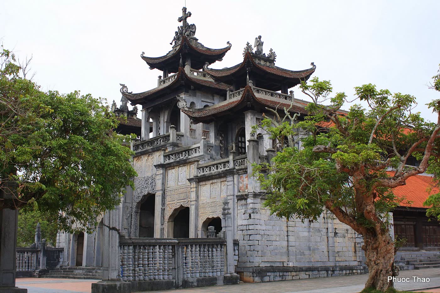 The carved stone church front with a cross at Phát Diệm