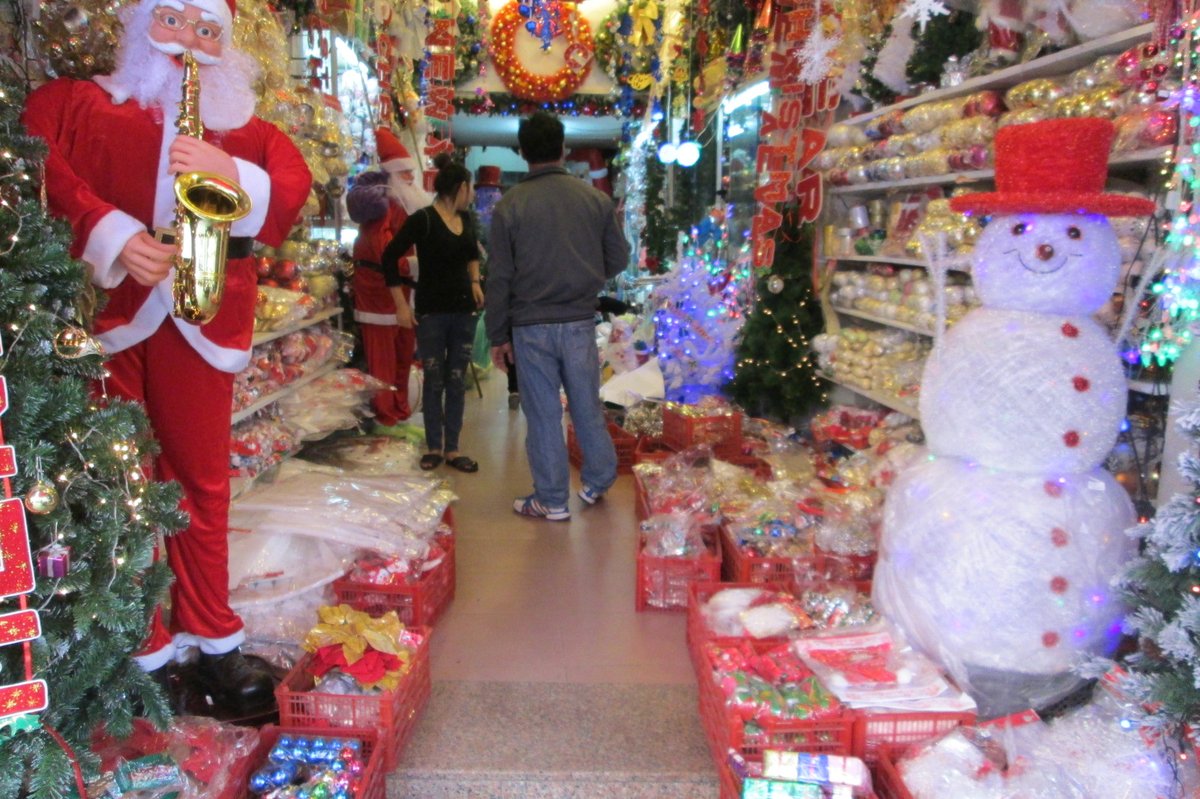 A shop aisle packed with Christmas decorations, a saxophone-playing Santa on the left and a snowman on the right