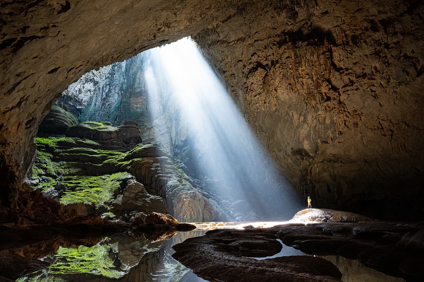 A sunbeam in the first doline, with a person on the rock for scale