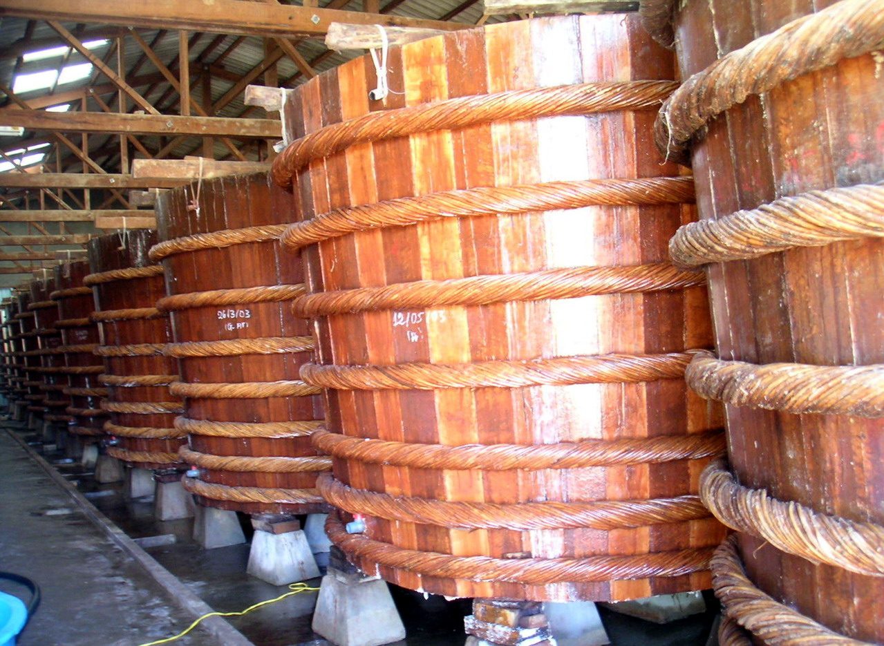 Rows of wooden fish-sauce vats bound with rope on Phu Quoc