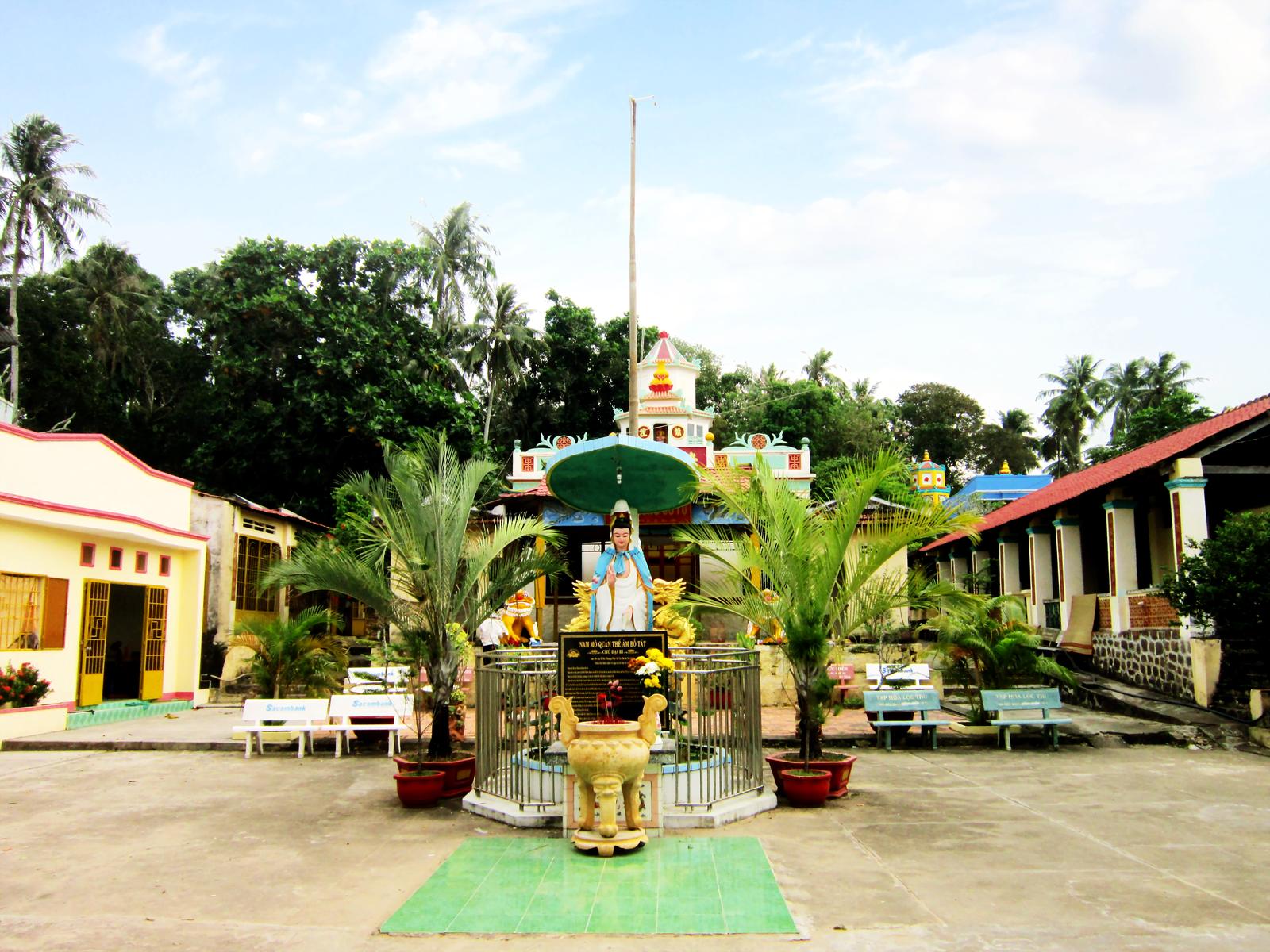 The courtyard at Sùng Hưng, with the statue, the incense, and the hall
