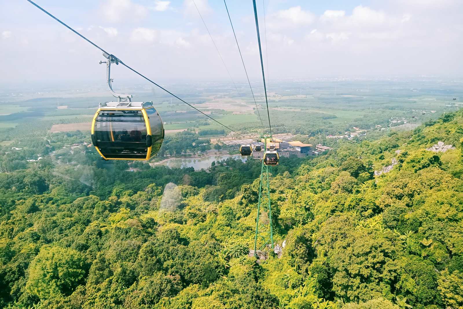 A cable cabin over the forest, with the plain beyond
