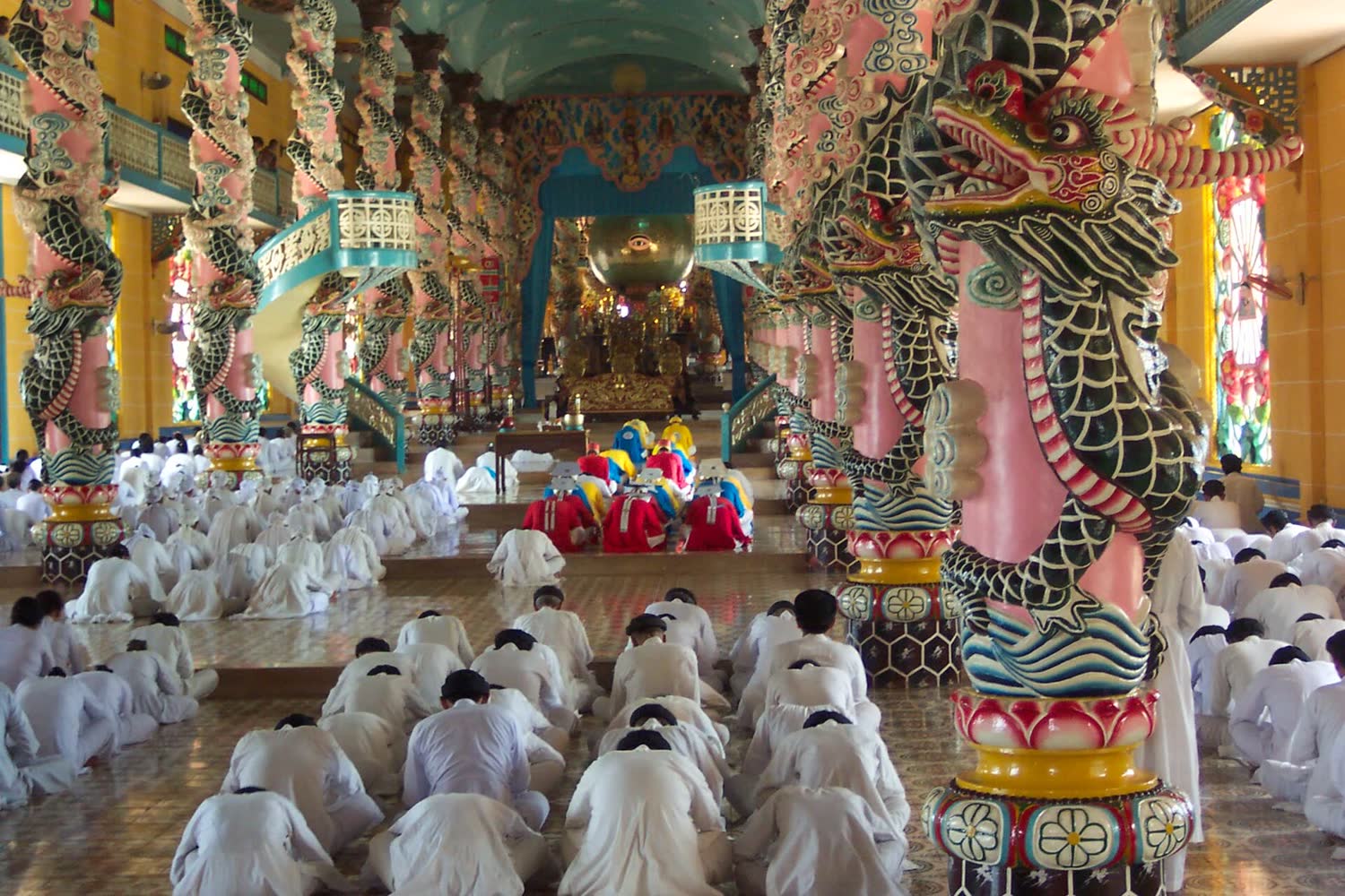 Worshippers in white inside the Cao Dai Holy See prayer hall