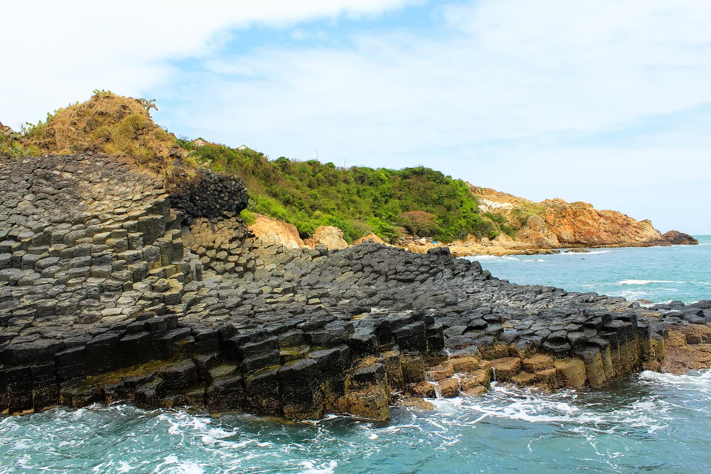 Tall black basalt columns at Ganh Da Dia, with the sea along the cliff